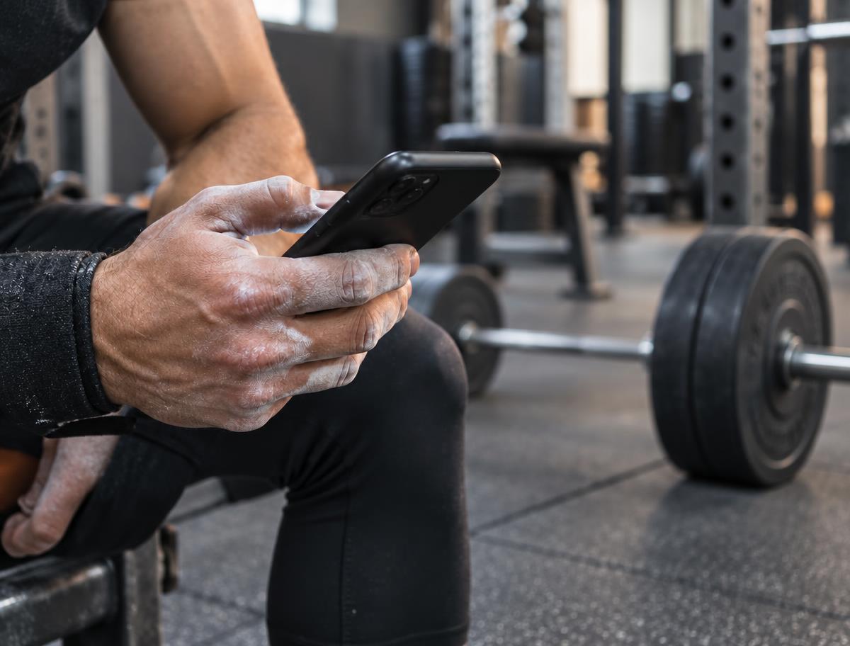 Athlete holding a phone showing their ALTA training session